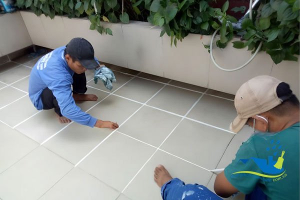 Công nhân thi công trám ron gạch chống thấm sân thượng đã lát gạch bằng keo chuyên dụng